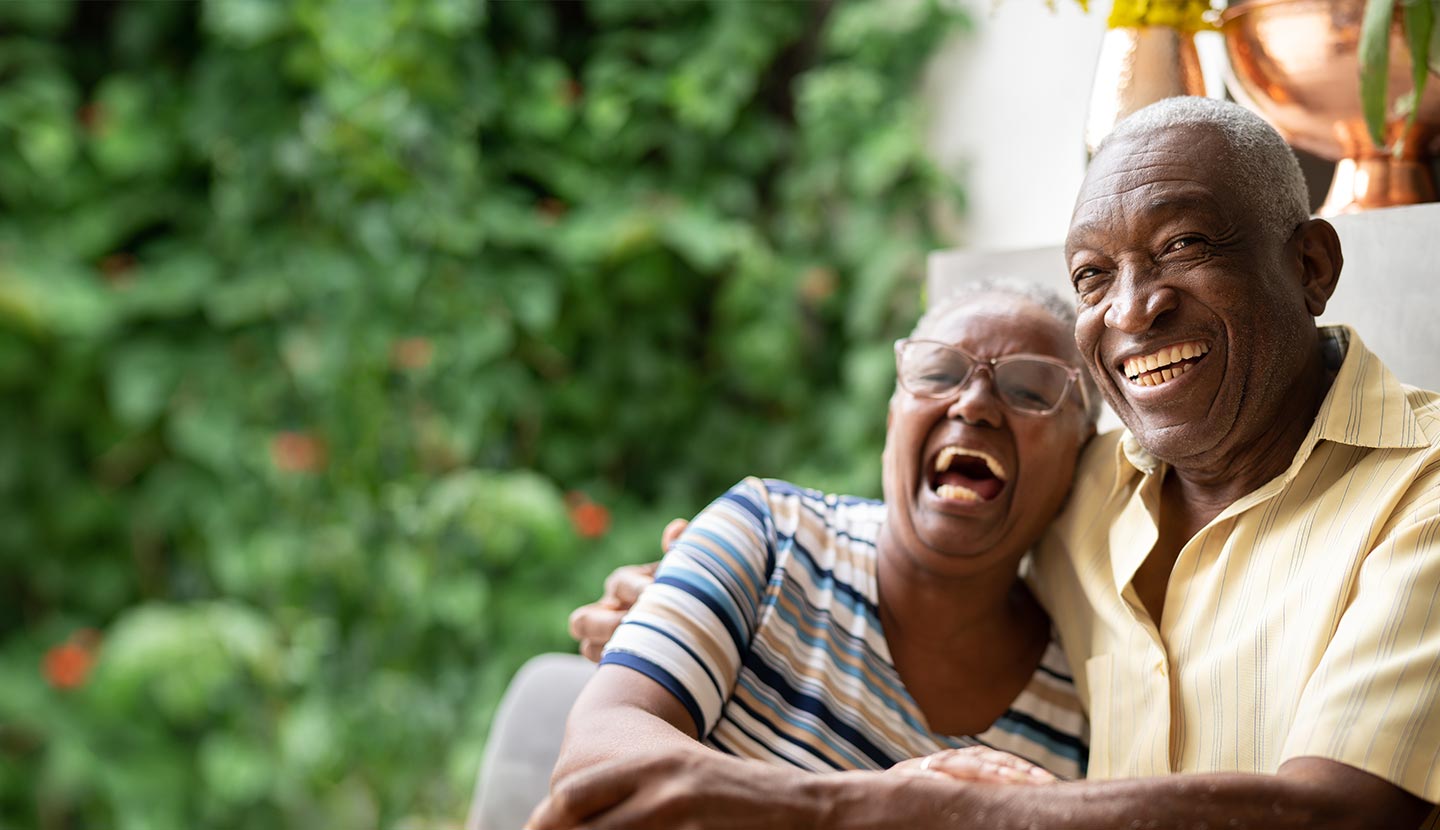 Older African American couple laughing, outdoors