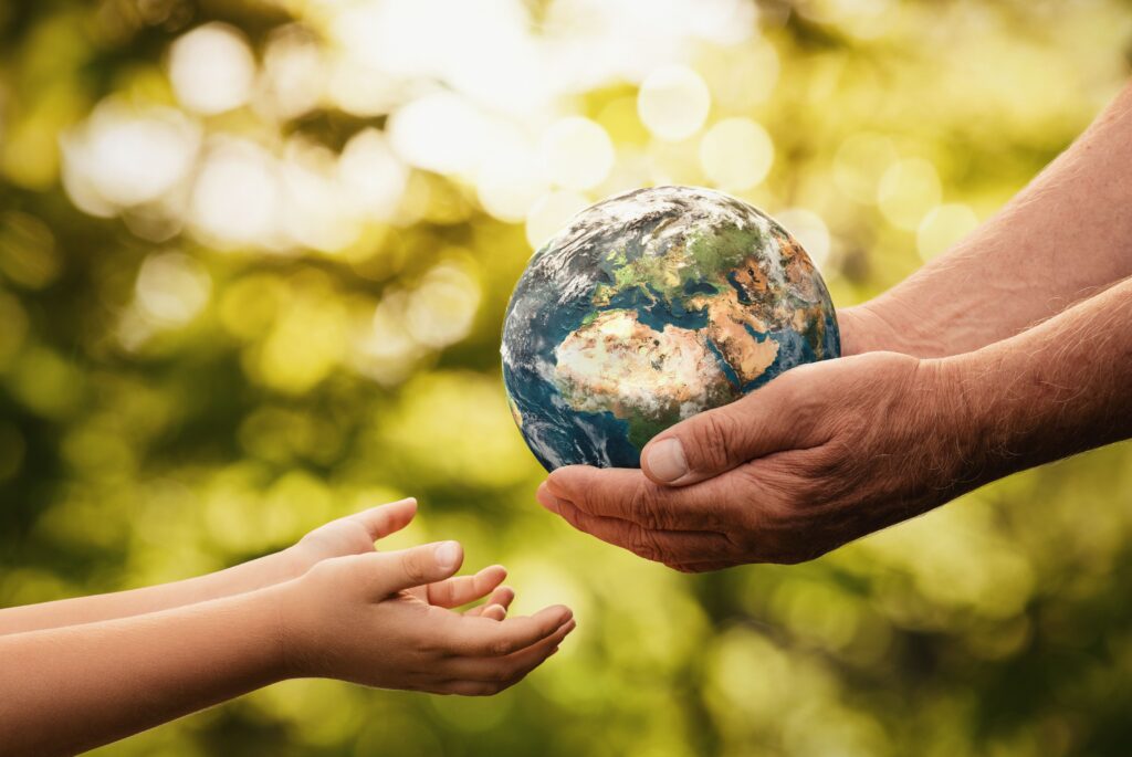 Senior hands and child hands holding the Earth for Earth Day